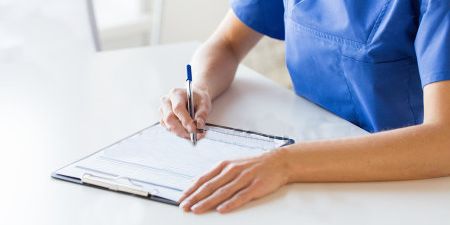 Nurse writing on notepad